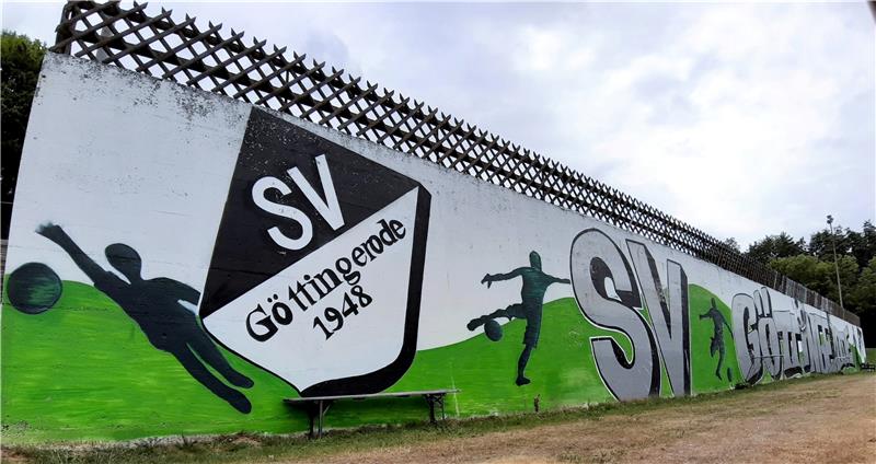 Die Wand unterhalb der Zufahrt zum SVG-Vereinsheim hat seit Sommer 2021 ein Graffiti. Für ältere Mitglieder ist noch in Erinnerung, dass Teile der Mauer in einer Aprilnacht des Jahres 1973 umkippt. Niemand wird verletzt. Fotos: Privat, Potthast, Schlegel