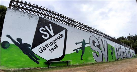 Die Wand unterhalb der Zufahrt zum SVG-Vereinsheim hat seit Sommer 2021 ein Graffiti. Für ältere Mitglieder ist noch in Erinnerung, dass Teile der Mauer in einer Aprilnacht des Jahres 1973 umkippt. Niemand wird verletzt. Fotos: Privat, Potthast, Schlegel