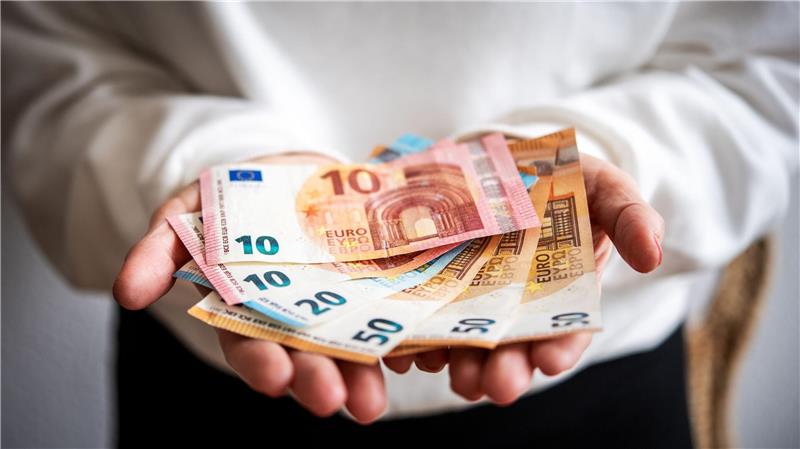 Eine Person hält sechs Geldscheine in ihren Händen.