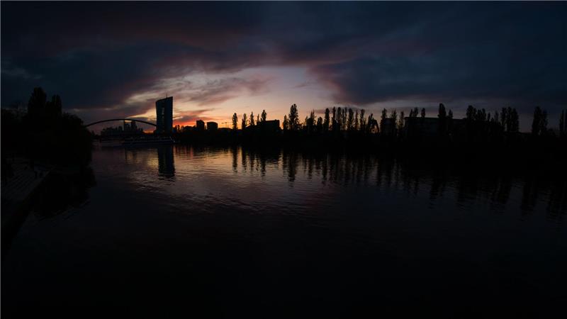 Die Zentrale der Europäischen Zentralbank (EZB) hebt sich im letzten Licht des Tages vor dem Himmel ab.