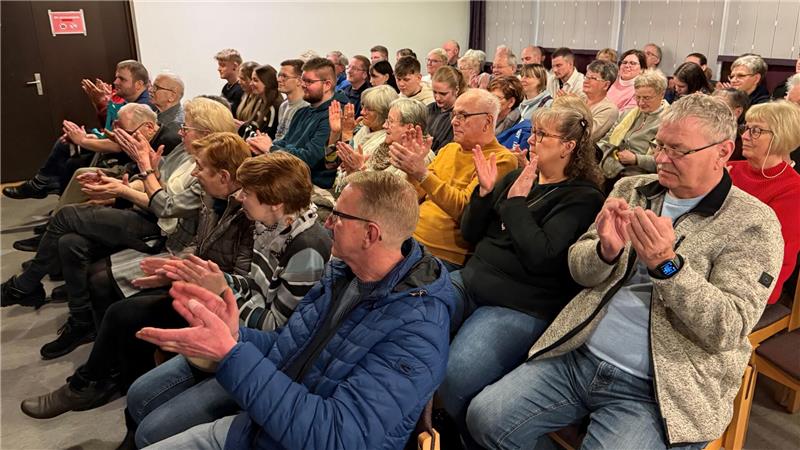 Das Foto zeigt viele Menschen, die Beifall klatschen.