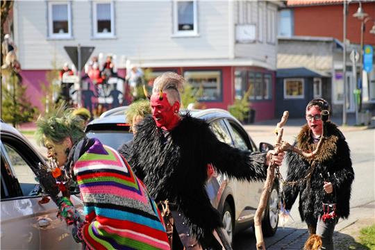 Die als Hexen und Teufel verkleideten Mitglieder der Walpurgissippe St. Andreasberg halten die Autos an der Schützenstraße an, um ihnen kleine Hexen- und Teufelspuppen zu verkaufen. Foto: Jung