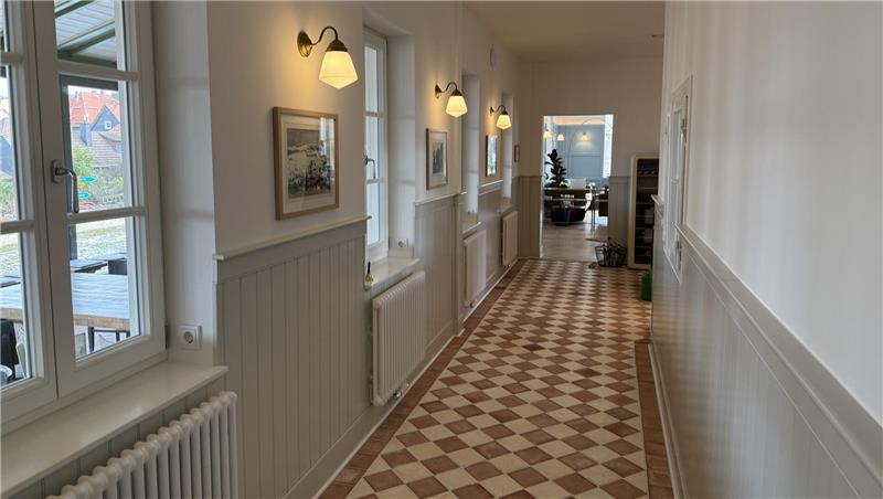 Das Foto zeigt einen Flur mit alten Fliesen.