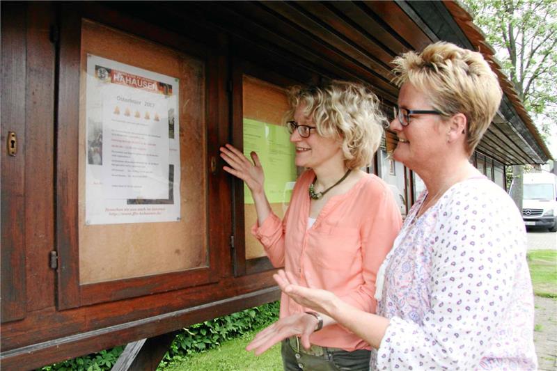 Die angehenden Dorfmoderatoren Claudia Mehl (li.) und Petra Kremeik aus Hahausen präsentieren im Schaukasten der Freiwilligen Feuerwehr ihr Veranstaltungsplakat für den gemeinsamen Marsch zum Osterfeuerplatz.  Foto: Kühlewind