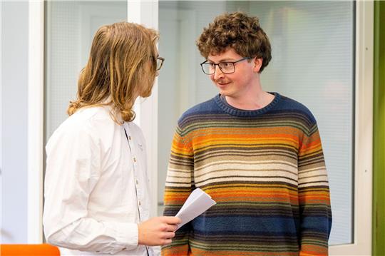 Die angeklagten Klimaaktivisten Lukas Popp (l) und Simon Lachner unterhalten sich vor dem Prozessauftakt.