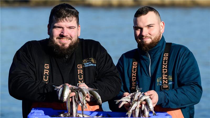 Die beiden Brüder und Fischer Per-Willem (l) und Jonas Grube halten frischen Stint in den Händen. 