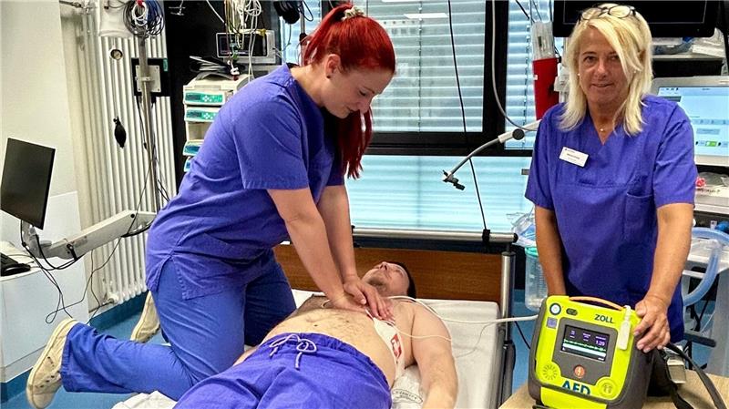 Wenn jede Sekunde zählt: Präventionsrat startet Initiative Die beiden Fachschwestern Linda Baumgarten (li.) und Marion Kruse demonstrieren an einem Kollegen eine simulierte Reanimation mit einem Defibrillator.