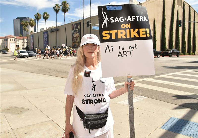 Die britisch-amerikanische Theater- und Filmschauspielerin Frances Fisher steht mit einem Streikschild vor den Warner Bros. Studios.