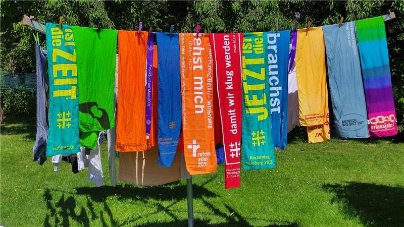 Die bunten Tücher sind kultiges Sammelobjekt bei gestandenen Kirchentag-Teilnehmern. Zu jeder Veranstaltung gibt es einen neuen Schal.