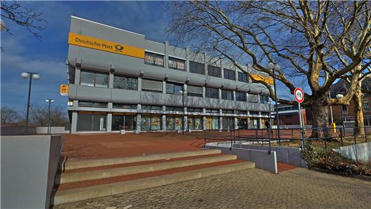 Mehrstöckiges Verwaltungsgebäude mit gelbem Schriftzug "Oberbürgermeister" und Treppenaufgang im Vordergrund