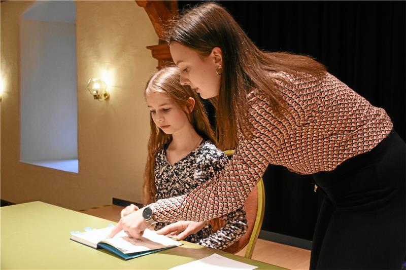 Vorlesewettbewerb: Hexen und Geister spuken im Schloss Die ehemalige Kreis-Praktikantin Lisa Lautenschläger zeigt den Teilnehmenden der zweiten Runde die Textstellen. Foto: Kempfer