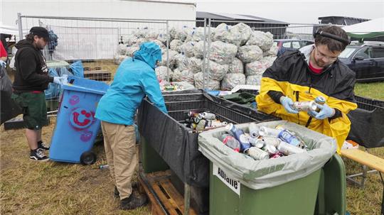 Die ehrenamtlichen Helfer sortieren im Backstage-Bereich die gespendeten Pfandosen und -flaschen.