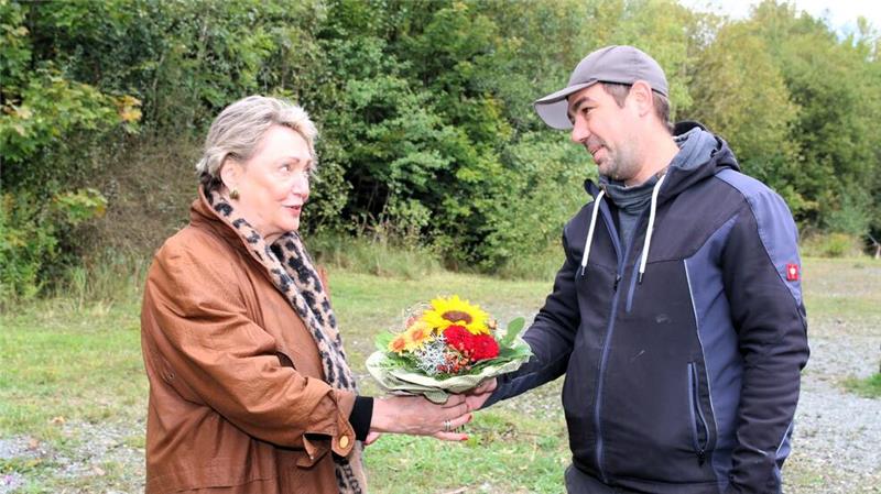 Die erste Vorsitzende Petra Rieke überreicht Blumen an Sebastian Scholz und begrüßt ihn damit als 100. Mitglied des Vereins „Hundefreunde Wolfshagen“.