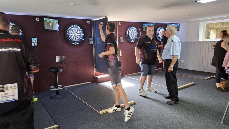 Jemand wirft Pfeile auf eine Dartscheibe.