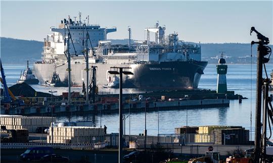 Die fast 300 Meter lange «Energos Power» läuft begleitet von Schleppern in den Hafen von Mukran ein.