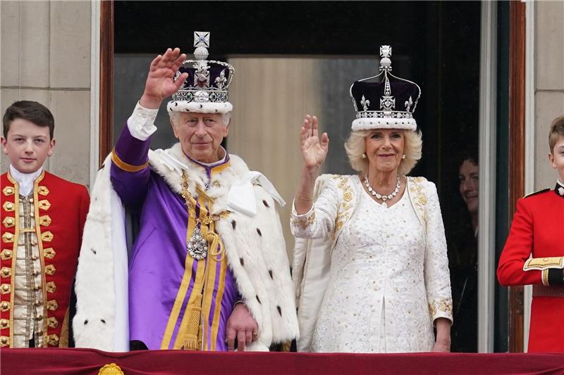 Tradition, Party und Protest: Charles und Camilla gekrönt Die frisch gekrönten König Charles III. und Königin Camilla winken vom Balkon des Buckingham Palastes der Menge zu.