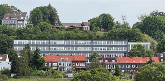 Das Foto zeigt einen großen Zweckbau mit ganz vielen Fenstern.