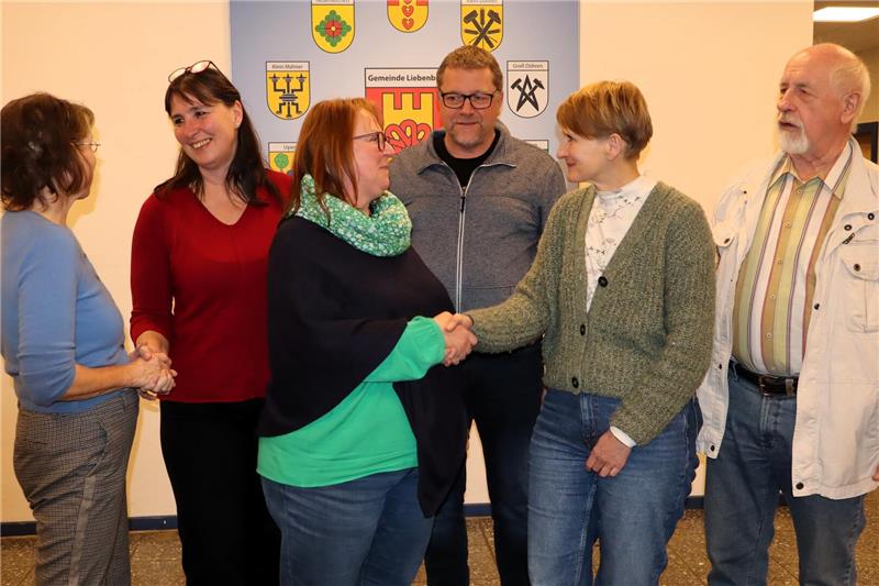 sechs Personen schütteln sich gegenseitig die Hände. 