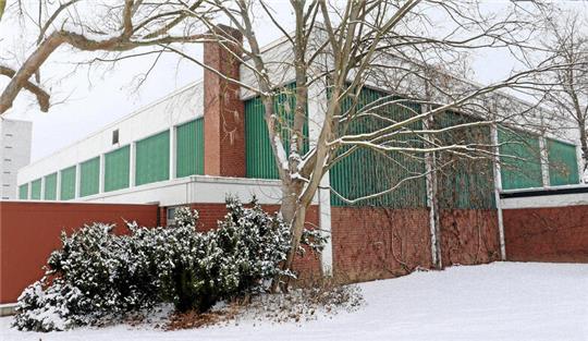Eine Sporthalle in verschneiter Landschaft.