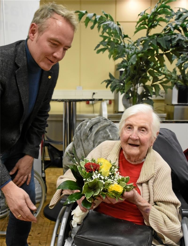 Lions Club Goslar: Beim Schneewalzer singen alle freudig mit Die hundertjährige Ruth Hiller erhält als älteste Teilnehmerin Blumen vom Lions-Präsidenten Philipp Stafe.