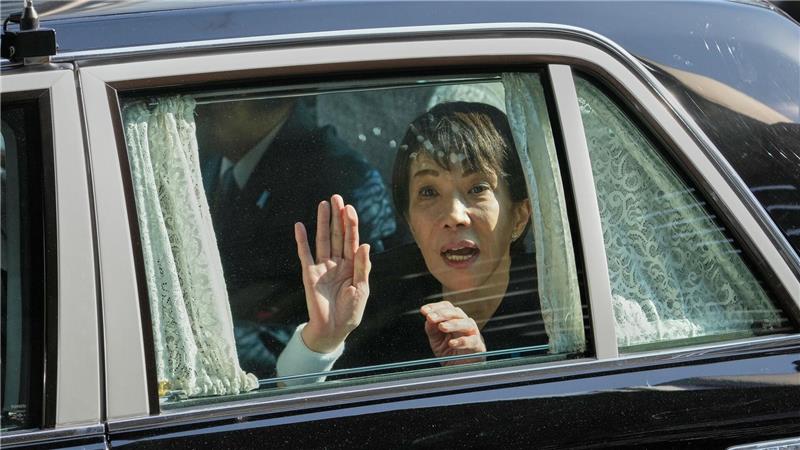 Die japanische Premierministerin Sanae Takaichi winkt von ihrem Fahrzeug aus.