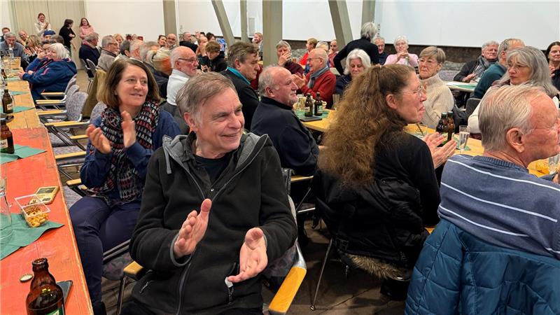 Das Foto zeigt einen vollen Saal und applaudierende Menschen.