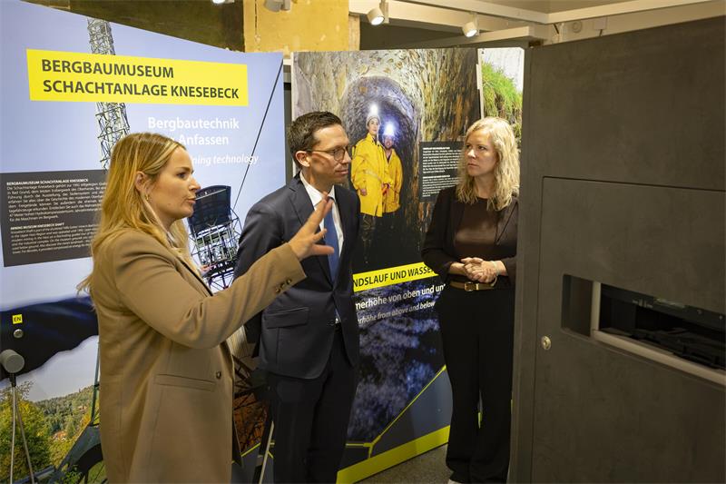 Zwei Frauen und ein Mann in einer Ausstellung.