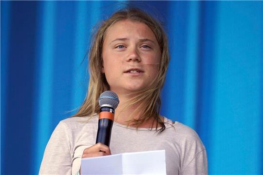 Die schwedische Klimaaktivistin Greta Thunberg steht während des Glastonbury Festivals auf der Bühne und spricht zum Publikum. Jetzt bringt sie ein großes Klimabuch heraus.)