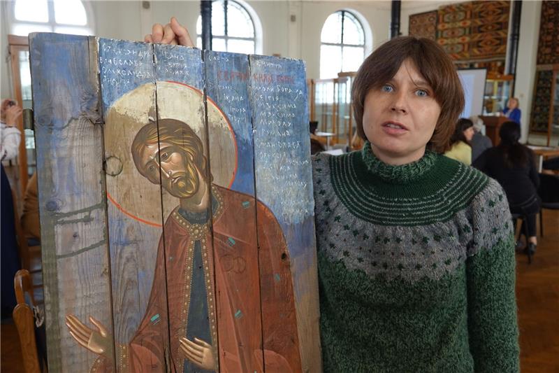 Kiewer Künstler malen Ikonen auf alte Munitionskisten Die ukrainische Künstlerin Sonja Atlantowa steht neben einer modernen Ikone im Museum für angewandte Kunst in Kiew.