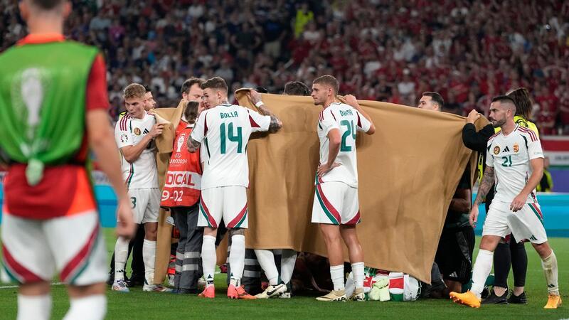 Varga-Unfall weckt furchtbare Erinnerungen Die ungarischen Spieler halten einen Sichtschutz, während Stürmer Barnabas Varga behandelt wird.