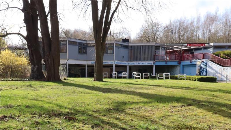 Bäume auf  Wiese. Haus im Hintergrund. 