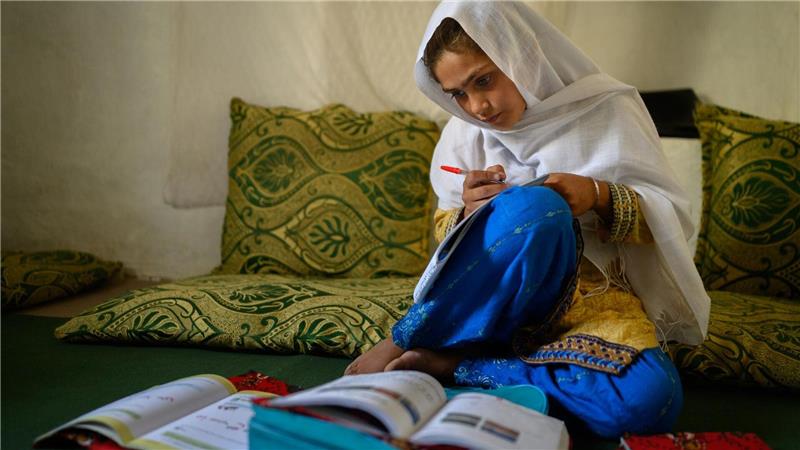 Die zehnjährige Hajira aus der afghanischen Provinz Nangarhar sitzt in einem Haus in einem abgelegenen Dorf östlich von Kabul über Schulbüchern und lernt. 