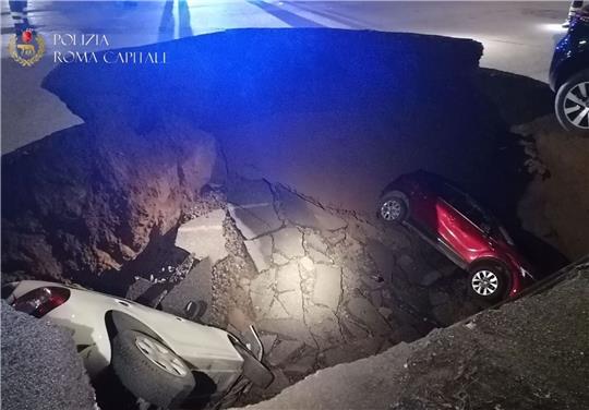 Die zwei geparkten Autos liegen in dem Erdloch.