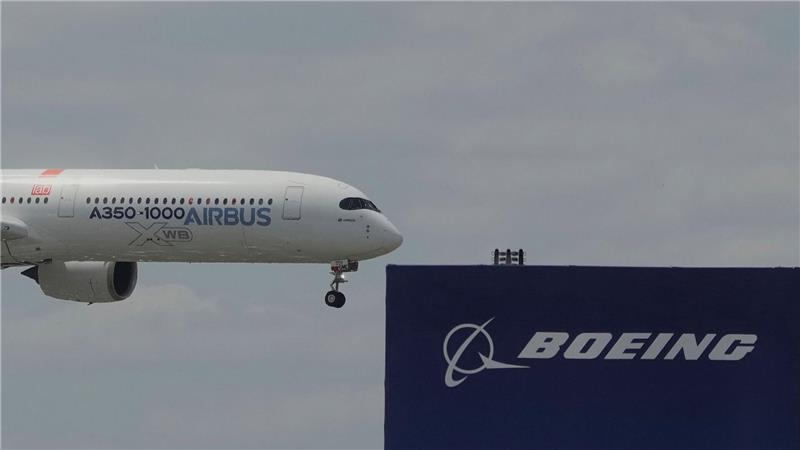 Airbus sammelt bei Messe Aufträge ein - Boeing geht leer aus Die zwei großen Konkurrenten: Ein Airbus fliegt bei einer Vorführung auf der Luftfahrtmesse Salon du Bourget an einem Logo von Boeing vorbei.