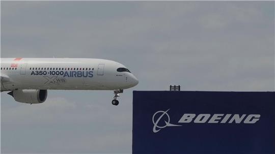 Die zwei großen Konkurrenten: Ein Airbus fliegt bei einer Vorführung auf der Luftfahrtmesse Salon du Bourget an einem Logo von Boeing vorbei.