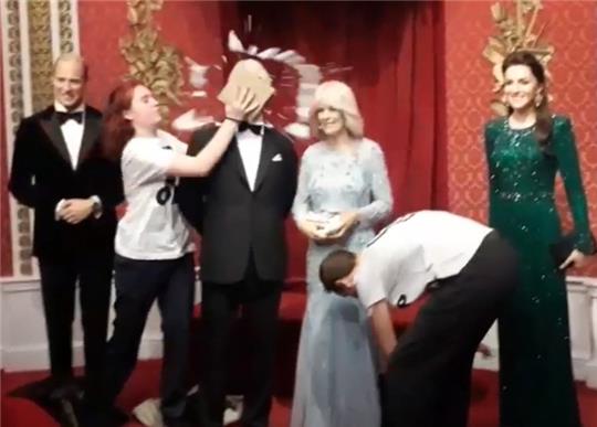 Dieses von der Umweltaktivistengruppe Just Stop Oil zur Verfügung gestellte Videostandbild zeigt zwei Aktivisten, die einen Schokoladenkuchen auf ein Wachsmodell von König Charles III. bei Madam Tussauds in London werfen. Foto: Just Stop Oil/PA Media/dpa