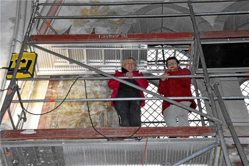 Diplom-Restauratorin Beate Skasa-Lindermeir (l.) und Dr. Maria Nötzel vom Kirchbauverein sind auf ein Podest geklettert, um eines der Gemälde aus nächster Nähe zu betrachten. Fotos: Roß