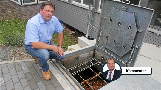 Das Foto zeigt einen Mann, der auf eine Holzhackschnitzelanlage blickt.