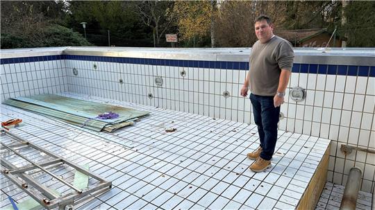 Das Foto zeigt einen Mann in einem leeren Schwimmbecken.