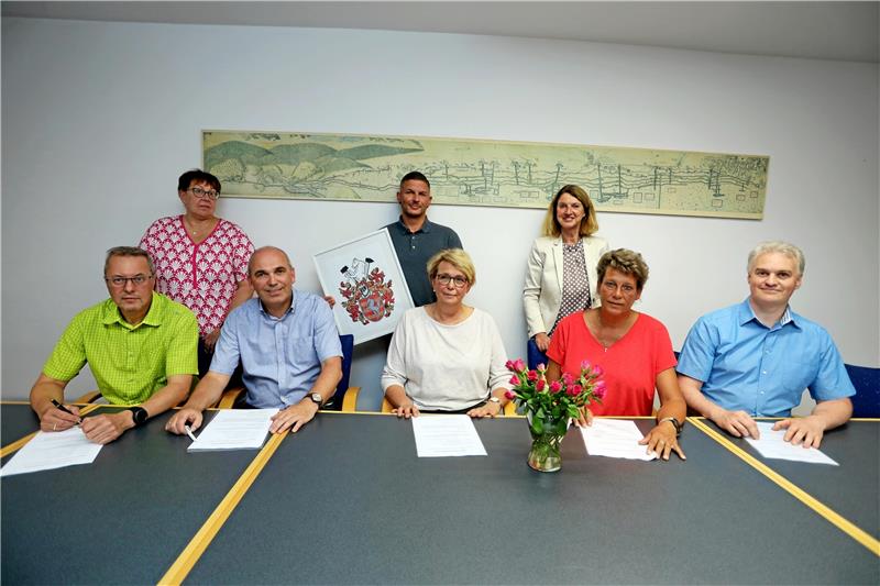 Im Oberharz wird gerödelt, Torjägerkanone für Torwart Dirk Losch (MTV Buntenbock), Jens Bergmann (FC Zellerfeld), Petra Hubert (TuS Clausthal-Zellerfeld) sowie Heike Hannig-Gröters und Joscha Mahlke (beide FC Altenau, vorn v. links) unterschreiben den Vertrag, Ute Taube von der Berg- und Universitätsstadt, FCZ-Sportwart André Schütte und Bürgermeisterin Petra Emmerich-Kopatsch schauen zu. Foto: Neuendorf