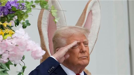 Donald Trump steht vor einem großen Osterhasen - und es sieht so aus, als hätte er sich die Ohren geliehen.
