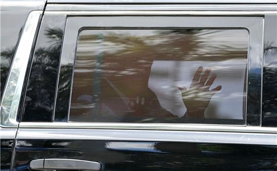 Donald Trump winkt auf dem Weg zum Gericht aus dem Fenster seiner Limousine.