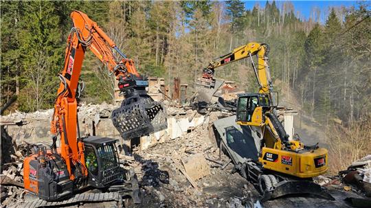 Zwei Bagger tragen Stück für Stück von der Brandruine ab. 