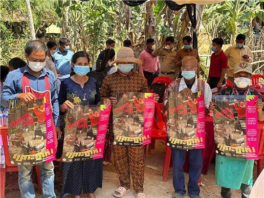 Dorfbewohner in der östlichen Provinz Prey Veng mit Plakaten, die auf die Bedrohung durch das Vogelgrippen-Virus aufmerksam machen.