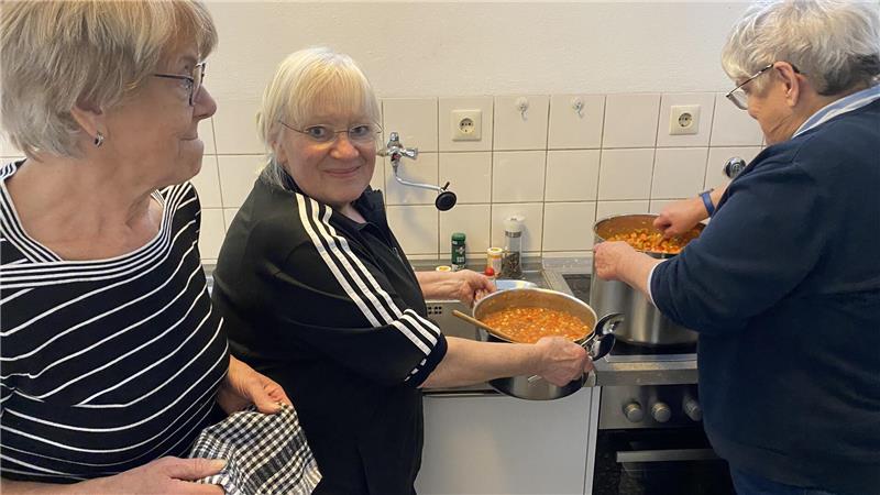 Doris Achtermann (M.) und Christa Benne schmecken die Suppe in der Küche gemeinsam ab. 