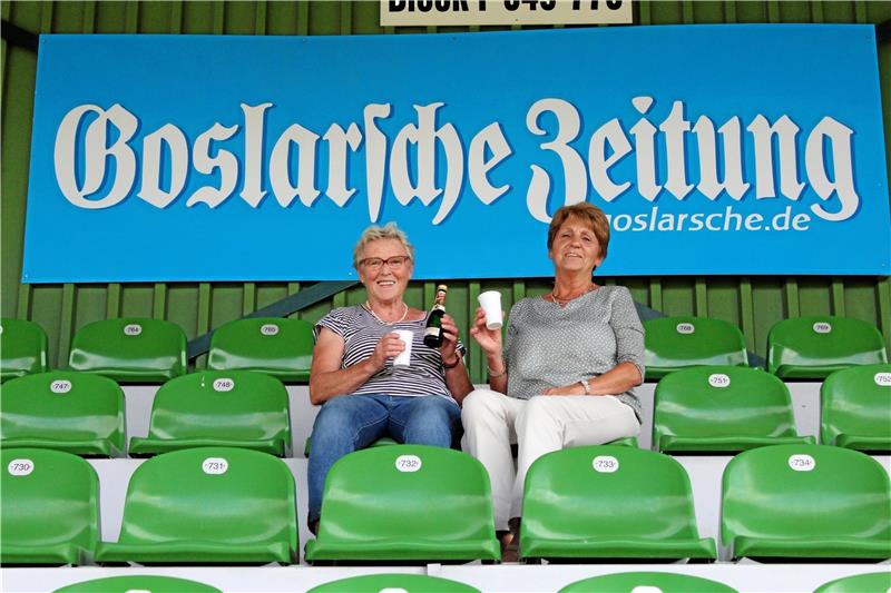 Doris Kosny und Inge Orbach lassen sich ihre Gewohnheiten nicht nehmen und stoßen auf der leeren Tribüne mit einem Piccolo an.  Fotos: Jens Sorge