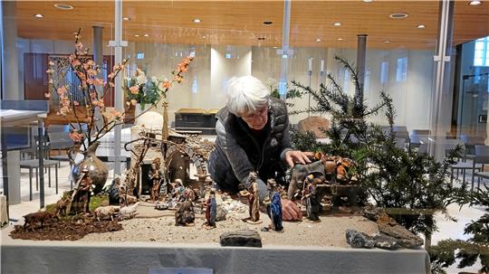 Dorothee Austen ordnet in der Winterkirche die Figuren der drei unterschiedlichen Krippen an. Foto: Skuza