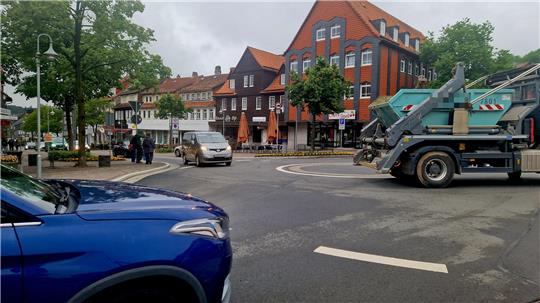 Autos fahren im Kronenplatz-Kreisel, Schulkinder versuchen die Straße zu überqueren.