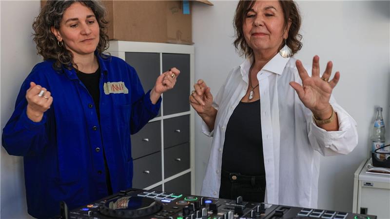 Uschi legt auf – wenn Seniorinnen DJ werden Dozentin Anna Cainelli (links) hilft DJ-Schülerin Ingrid Jatho, das Lied „Bauch Beine Po“ zu spielen.