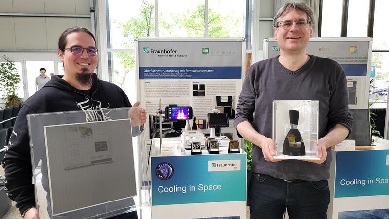 Dr. Felix Lederle und Professor Dr. Eike Hübner (r.) präsentieren laserbehandelte Metalle im Goslarer Fraunhofer Heinrich-Hertz-Institut. Drei Proben befinden sich derzeit auf der Raumstation ISS im Weltall.
